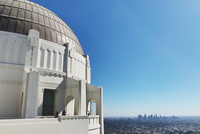 A domed building looking out over the sky and a large city